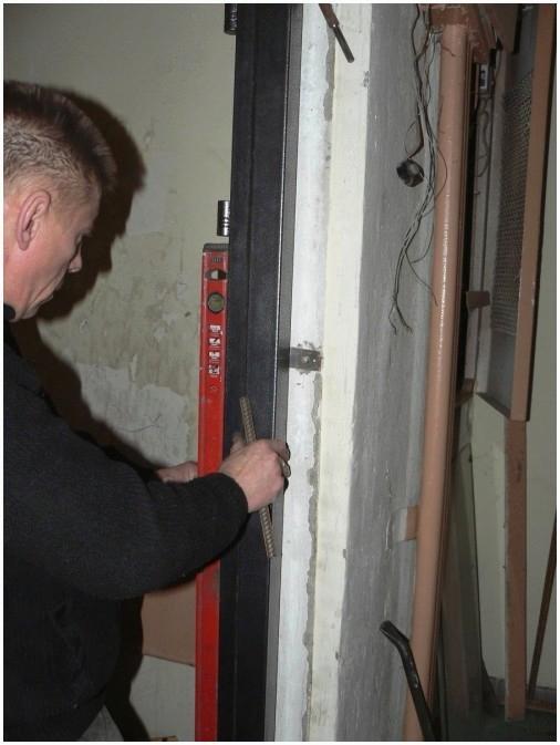 Проверяем вертикаль дверной коробки после засверливания отверстий